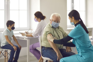Nurses giving flu shots to older adults and children during vaccination campaign